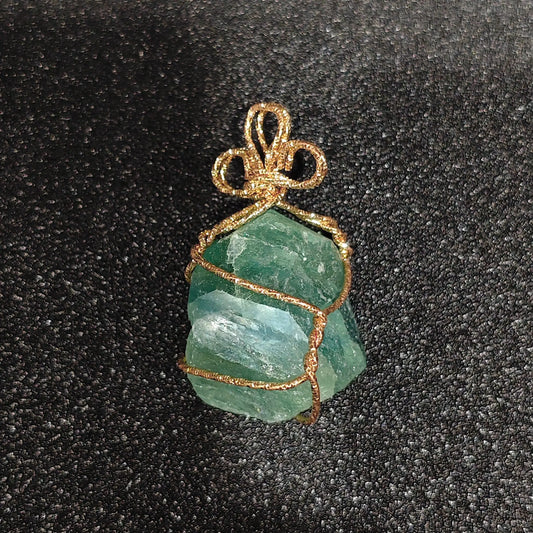 Raw mint green fluorite crystal chunk wrapped in gold-tone craft wire with decorative bow bail