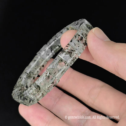 hand holding 17cm womens green mica clear quartz pyramid cut stretch bangle