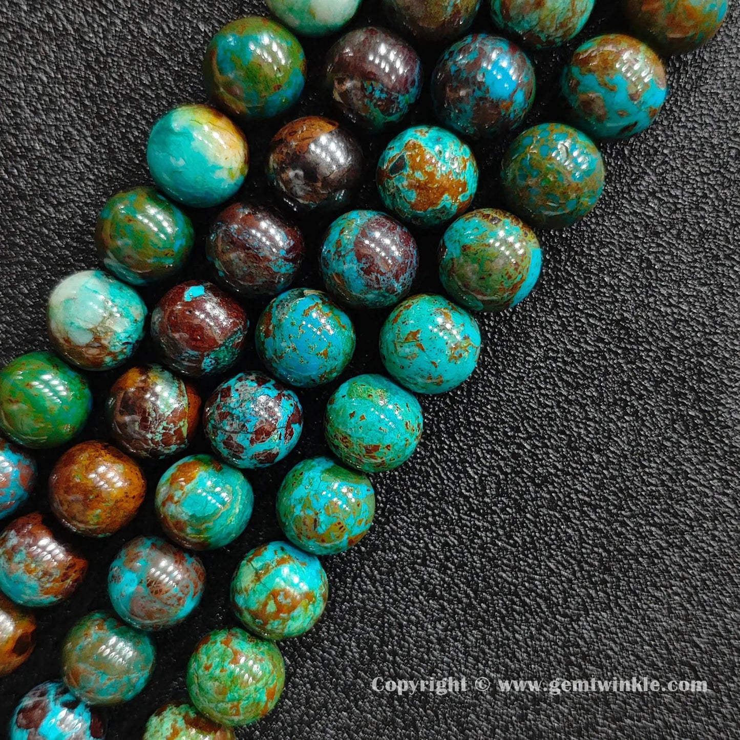 Angled view of green phoenix stone round bead strands arranged parallel on dark textured background