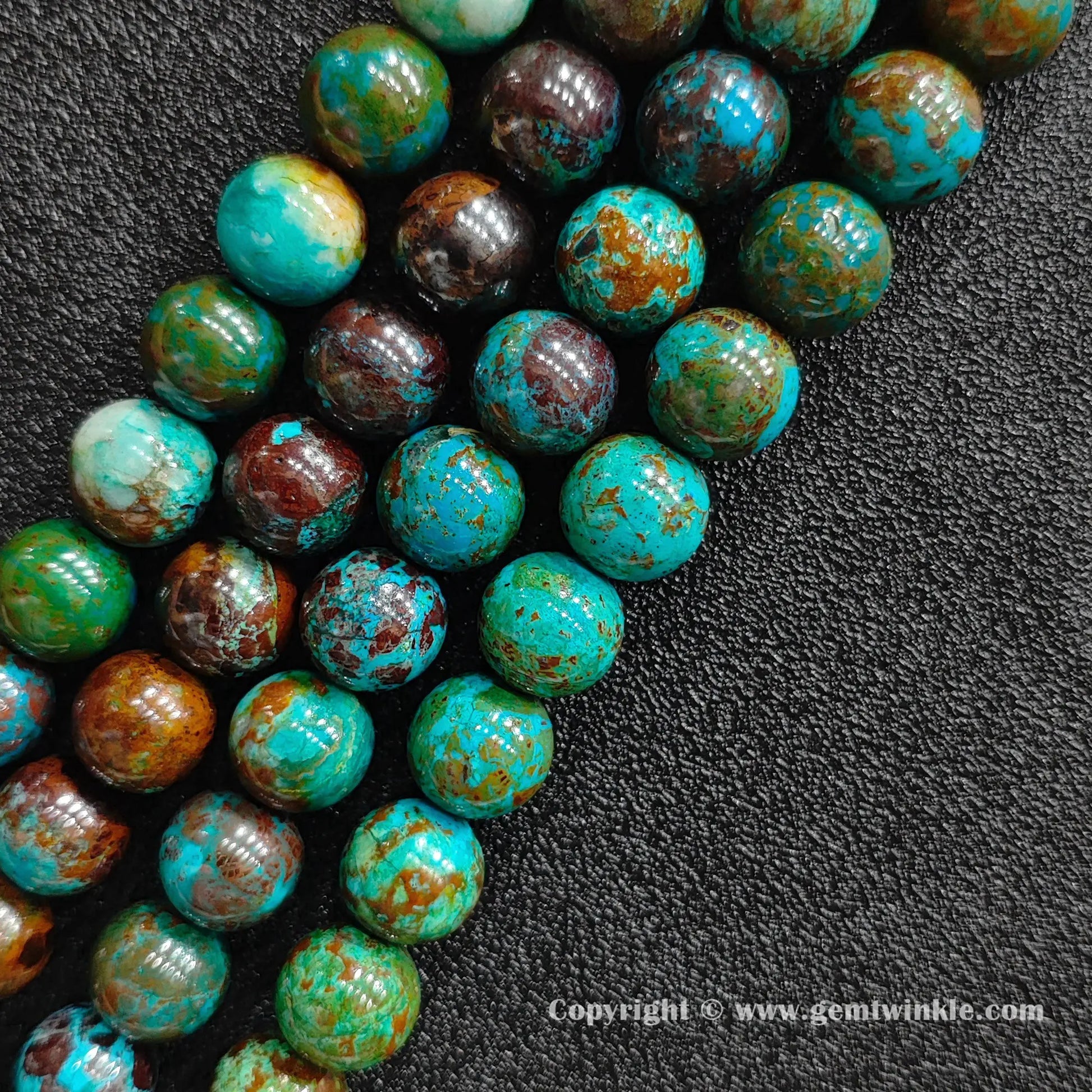 Angled view of green phoenix stone round bead strands arranged parallel on dark textured background