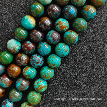 Angled view of green phoenix stone round bead strands arranged parallel on dark textured background
