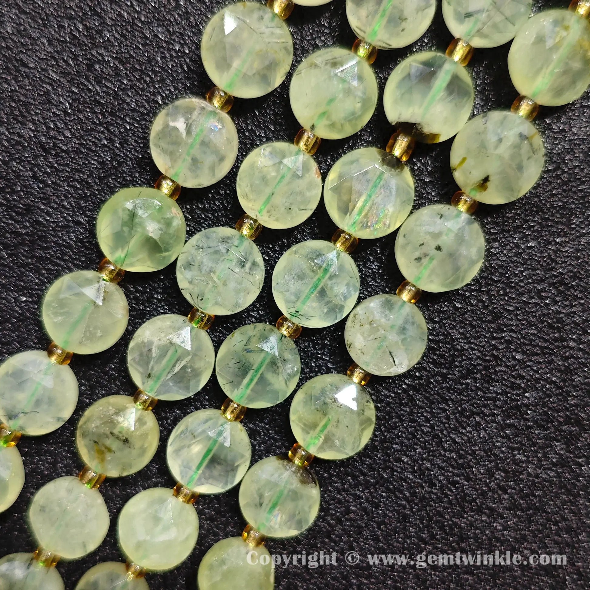 Close up view of translucent green prehnite star faceted flat beads showing facets