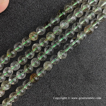 Diagonal display of multiple green quartz rutile loose beads strands for jewelry suppliers