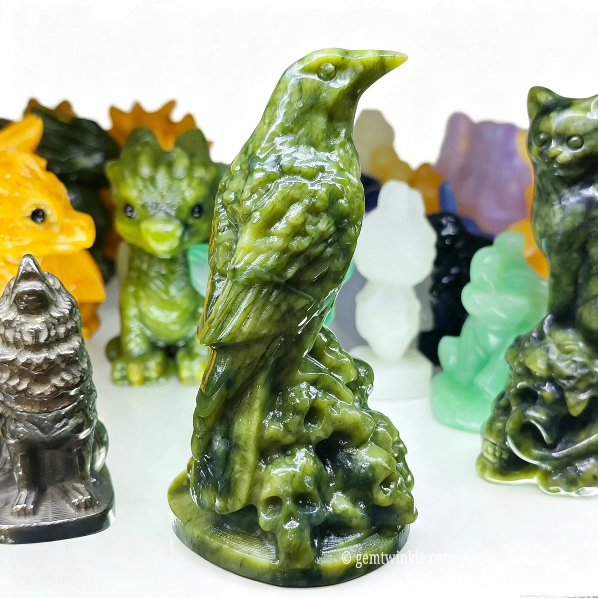 Side view of green serpentine raven carving showing detailed wing feathers perched on a skull base