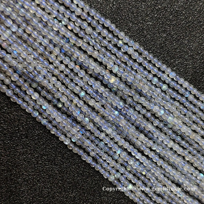 Full view of multiple delicate natural grey blue moonstone round seed strands on dark background