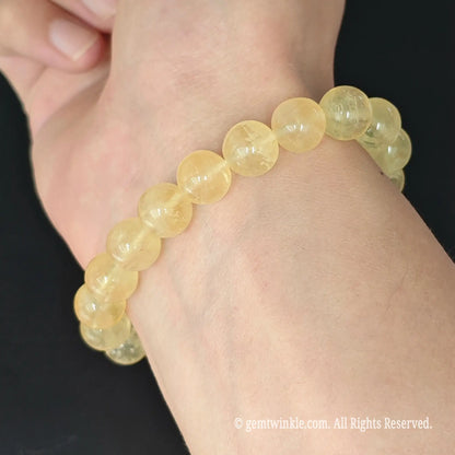 side view of natural yellow fluorite round bead stretch bracelet worn on wrist