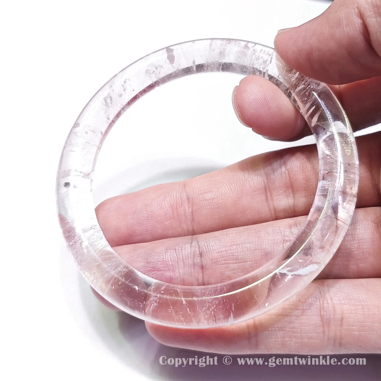 Handheld view showing transparent clear quartz bracelet transparency and smooth polished inner band