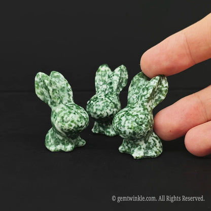 Handheld view of a 4cm green snowflake stone pocket pet rabbit demonstrating real tactile size for crystal shop buyers
