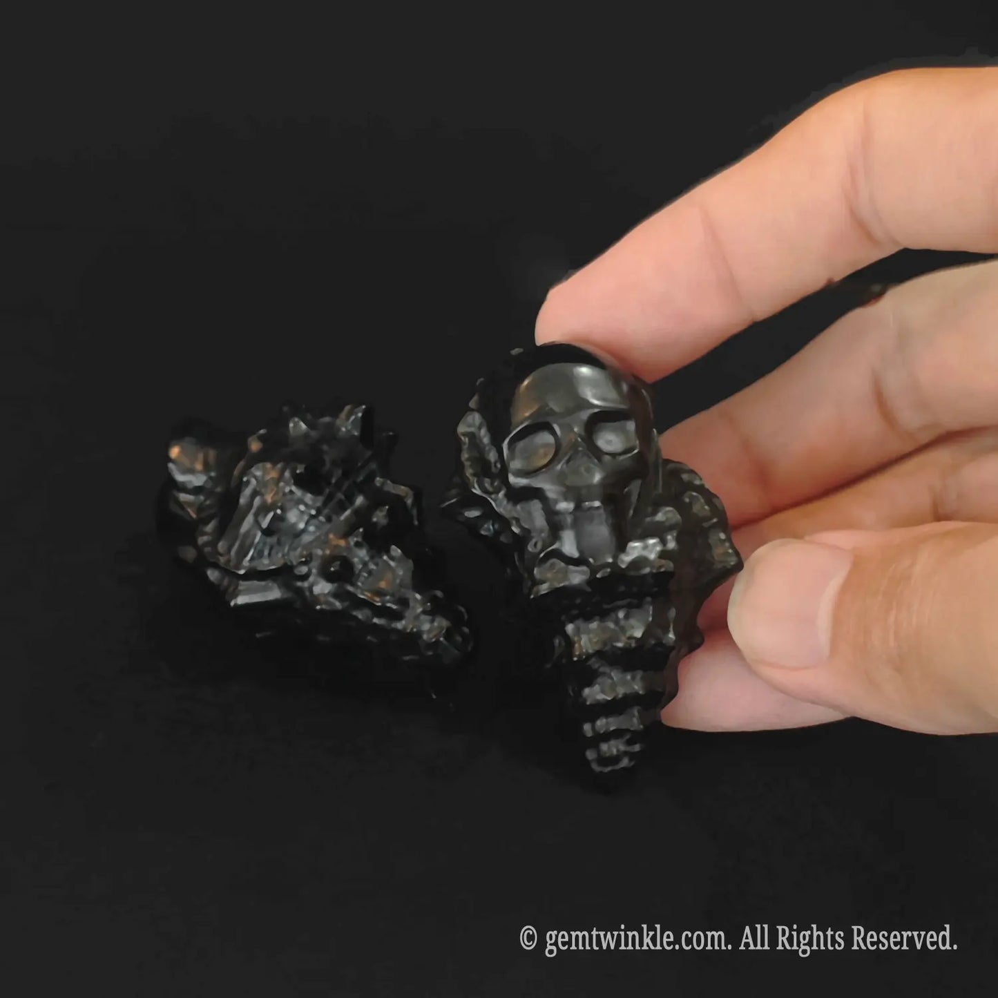 Handheld obsidian conch skull carving highlighting its 5cm compact size and organic detail