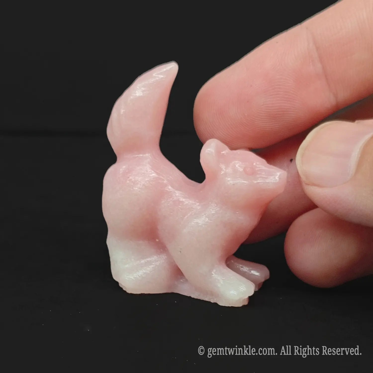Handheld view of a 4cm pink opal pocket pet companion puppy demonstrating miniature scale for boutique buyers