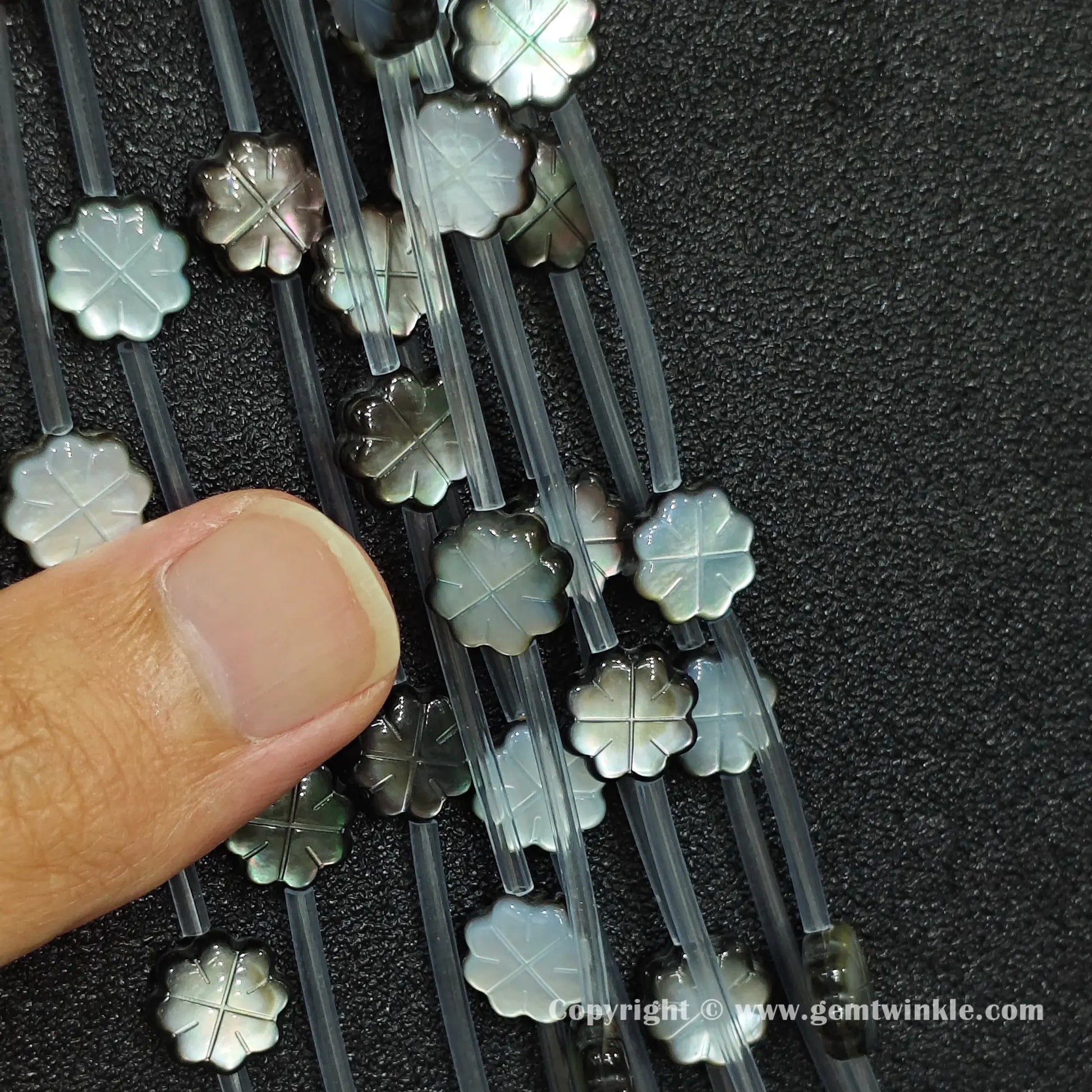 Handheld preview showing 10mm black shell plum blossom beads in hand