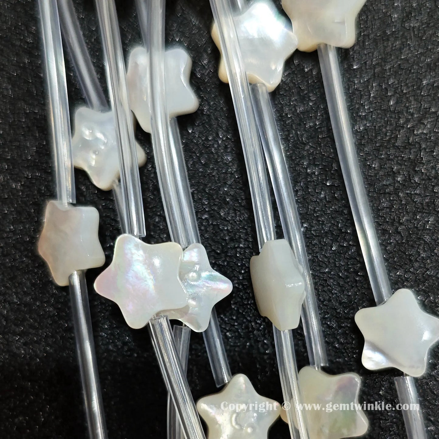 Handheld preview showing 10mm white shell smiley star beads in hand