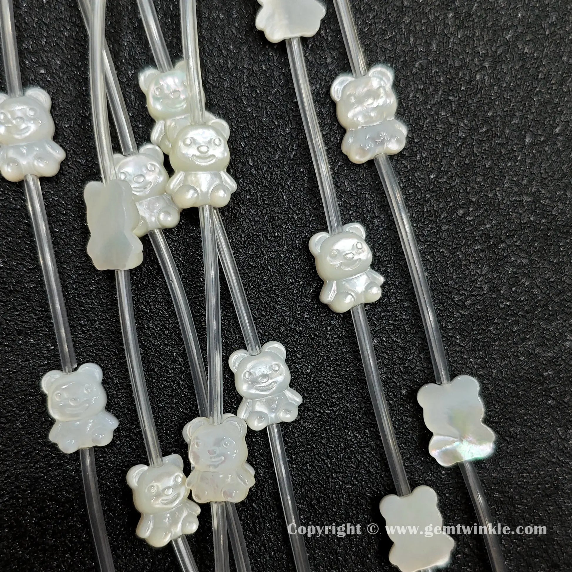 Handheld preview showing 11mm white shell teddy bear beads in hand