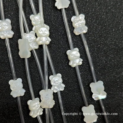 Handheld preview showing 11mm white shell teddy bear beads in hand