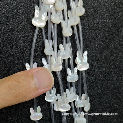 Handheld preview showing 11mm white shell bunny head beads in hand
