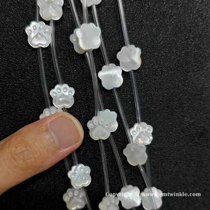 Handheld preview showing 11mm white shell cat paw beads in hand