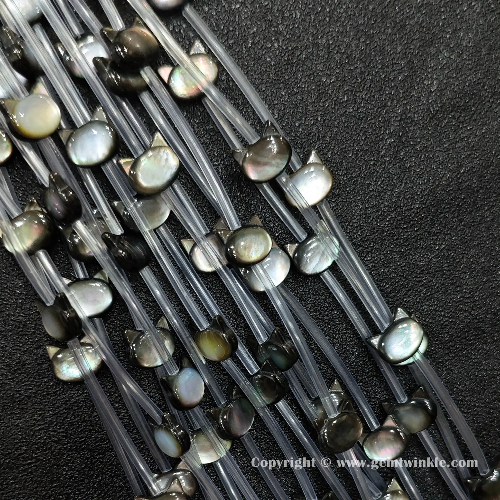 Handheld preview showing 6x7mm black shell kitty head beads in hand
