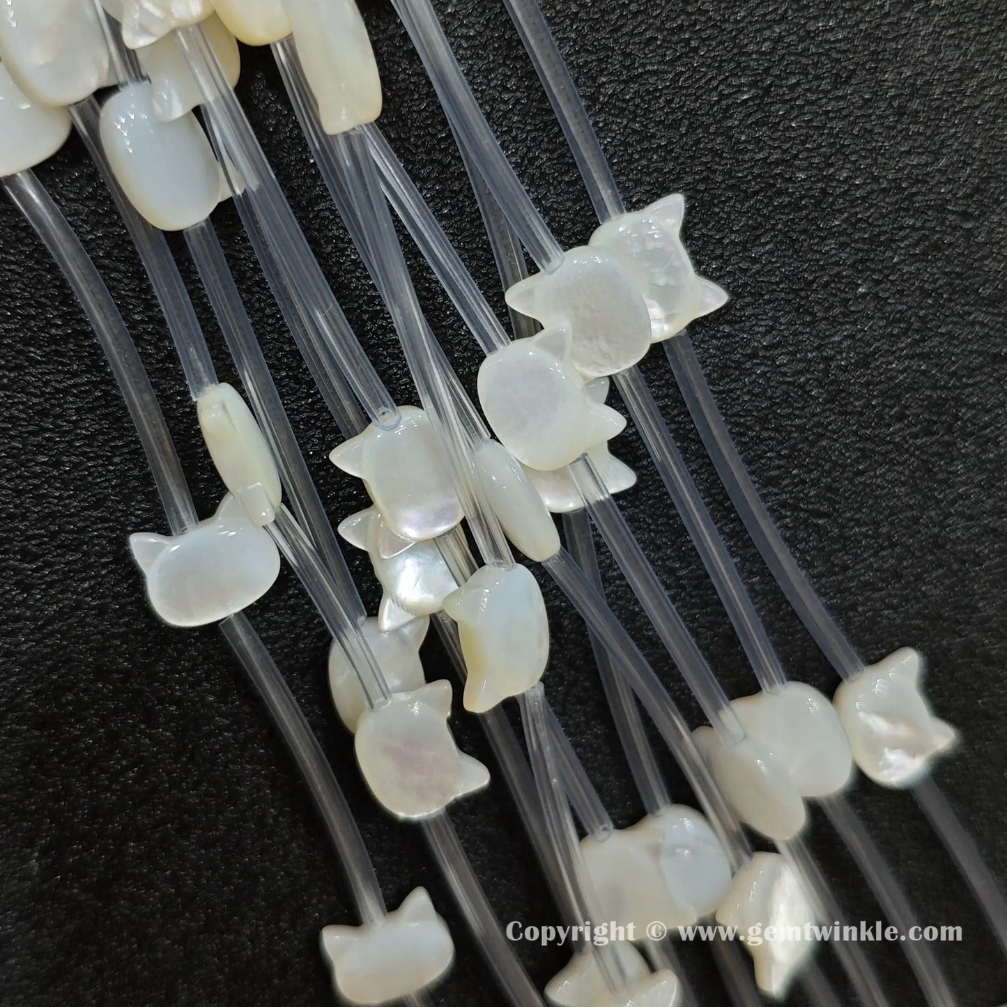 Handheld preview showing white shell kitty head beads in hand