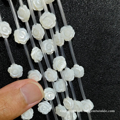 Handheld preview showing white shell rose flower carved beads in hand