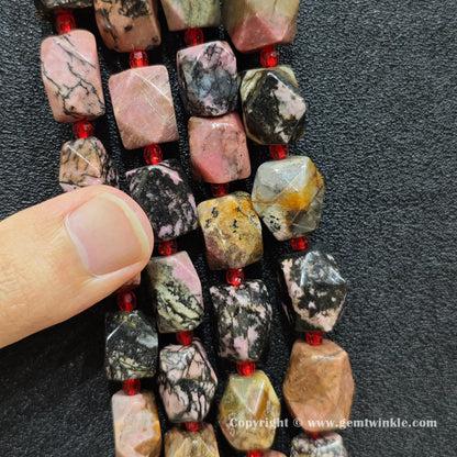 handheld scale view of 15mm faceted black veined rhodonite beads