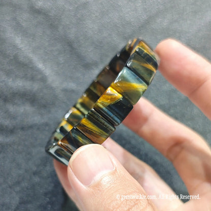 Close up view of hawk eye dual tone quartz wristband showing polished flat plate beads with silky luster