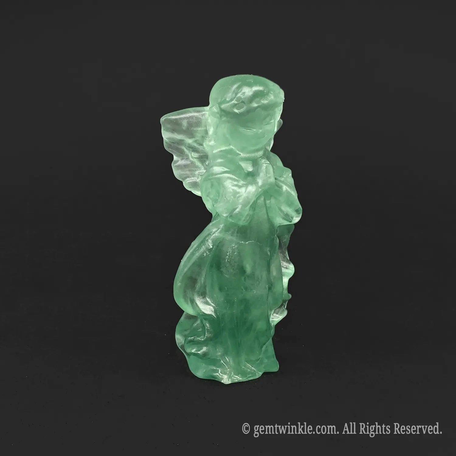 Three-quarter view of a hand-carved green fluorite healing crystal angel figurine displaying beautiful internal growth bands for aesthetic home decor
