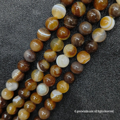 healing crystal beads wholesale featuring glossy color enhanced brown sardonyx lines with sharp espresso and cream parallel ribbon patterns