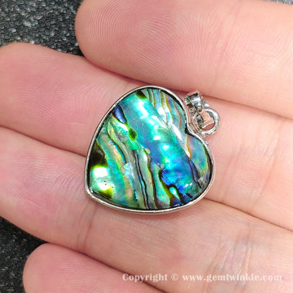 Close up handheld view showing silver top bail and colorful heart mosaic shell reflections