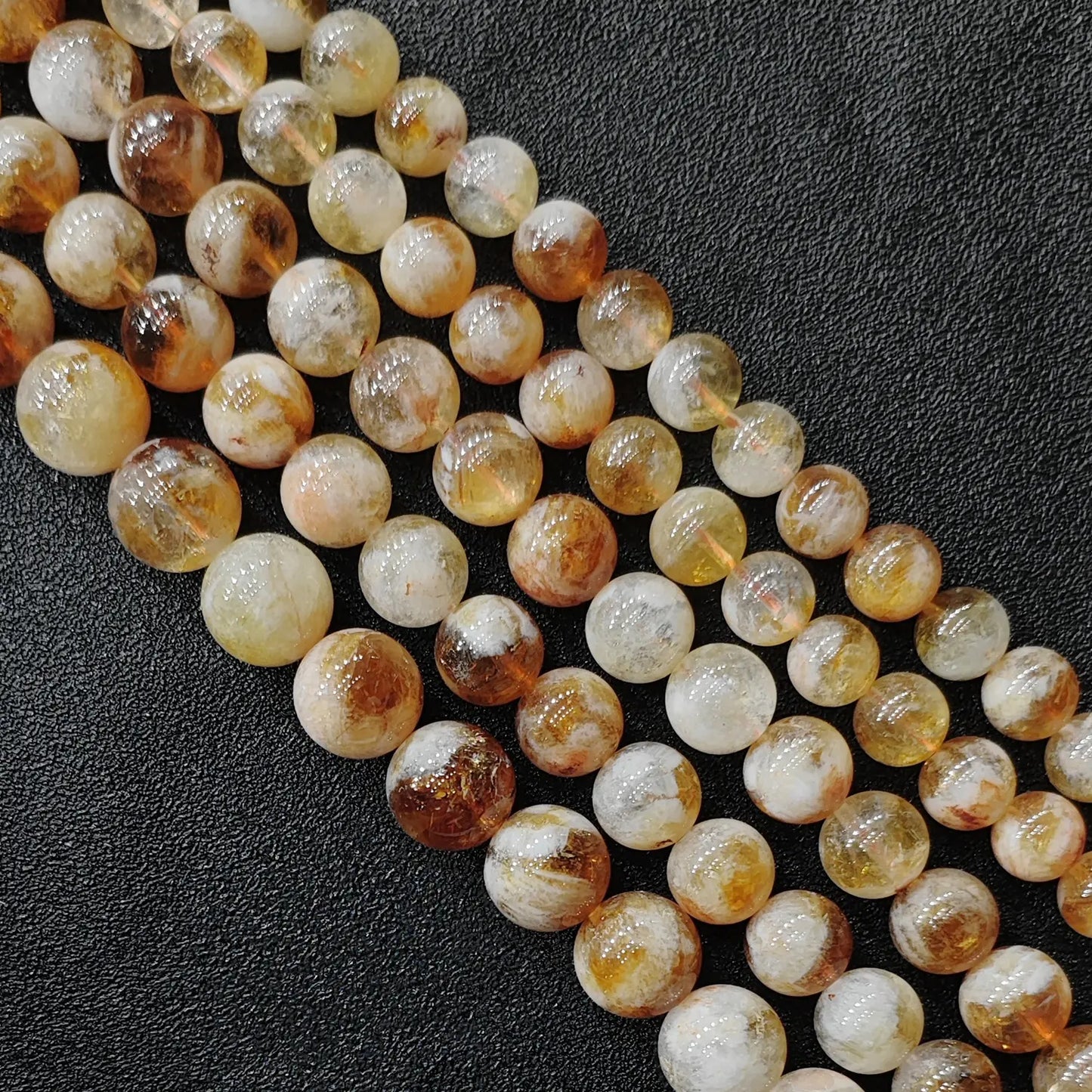 Macro view of budget friendly grade b- minus heat treated citrine phantom quartz round beads with heavy cloudiness