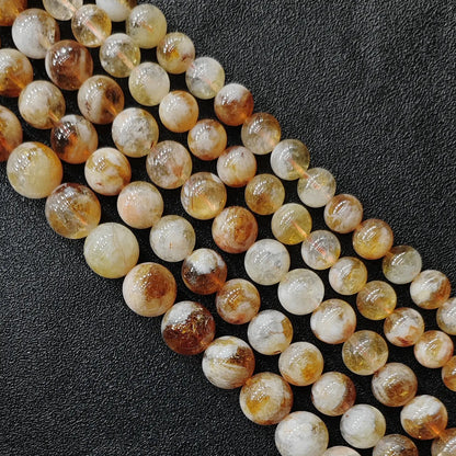 Macro view of budget friendly grade b- minus heat treated citrine phantom quartz round beads with heavy cloudiness
