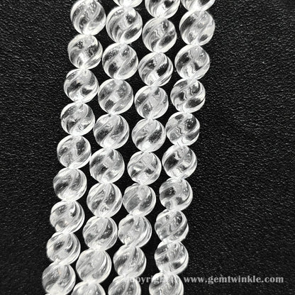 Vertical layout of helical grooved clear quartz beads highlighting carved texture