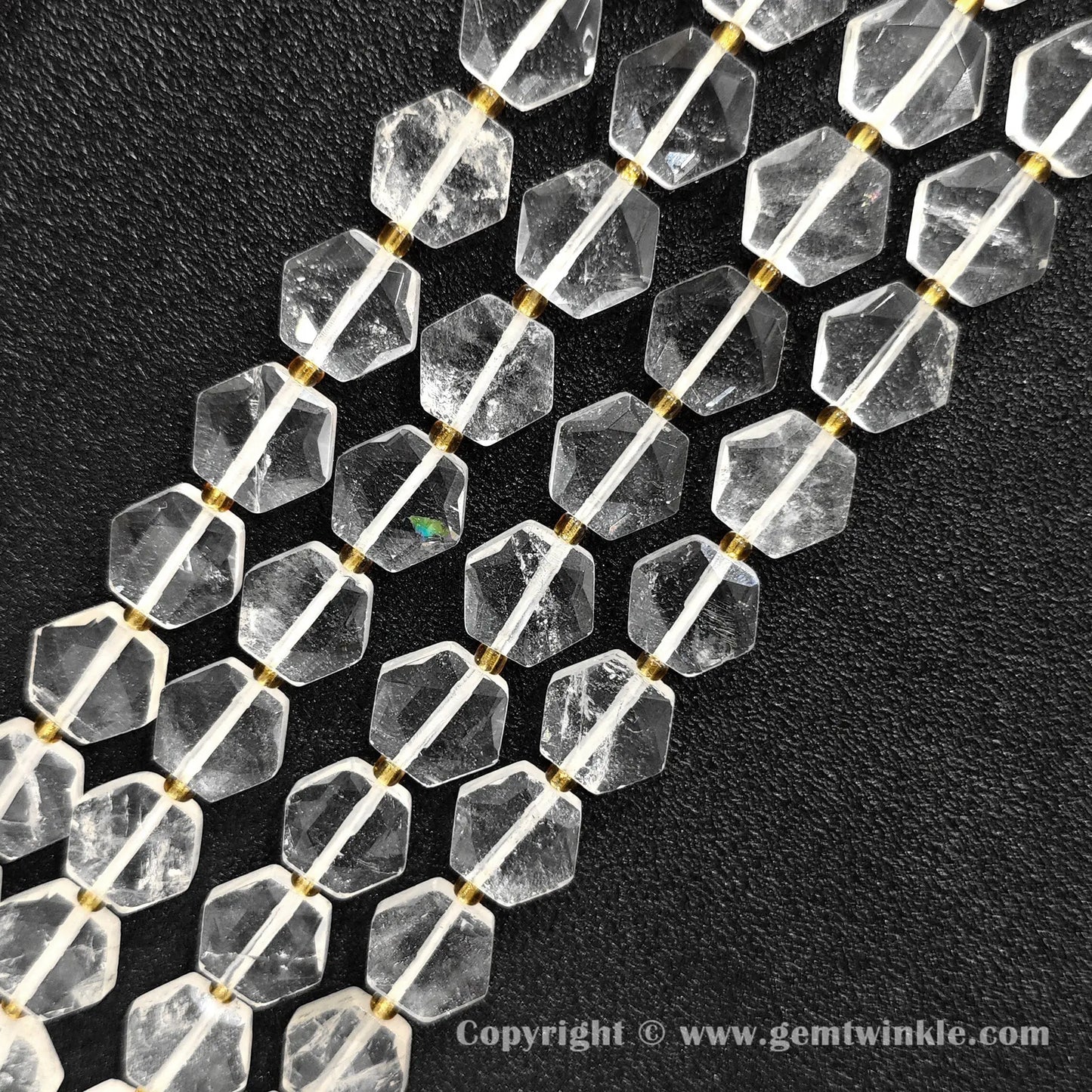 Close up view of hexagonal slice clear quartz beads on dark background