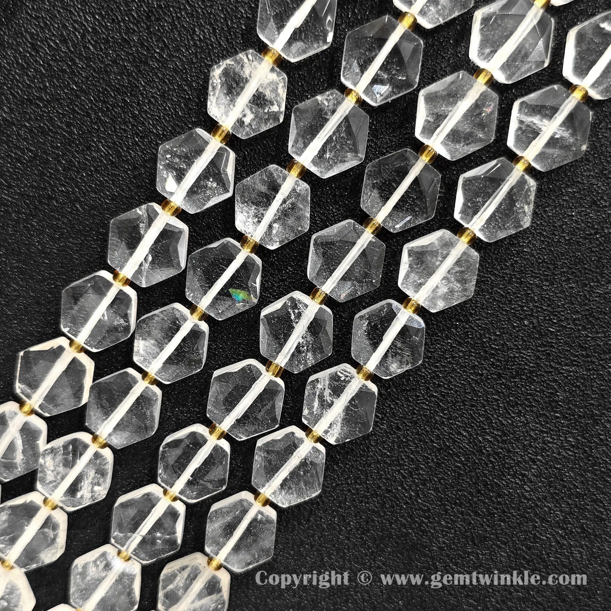 Close up view of hexagonal slice clear quartz beads on dark background