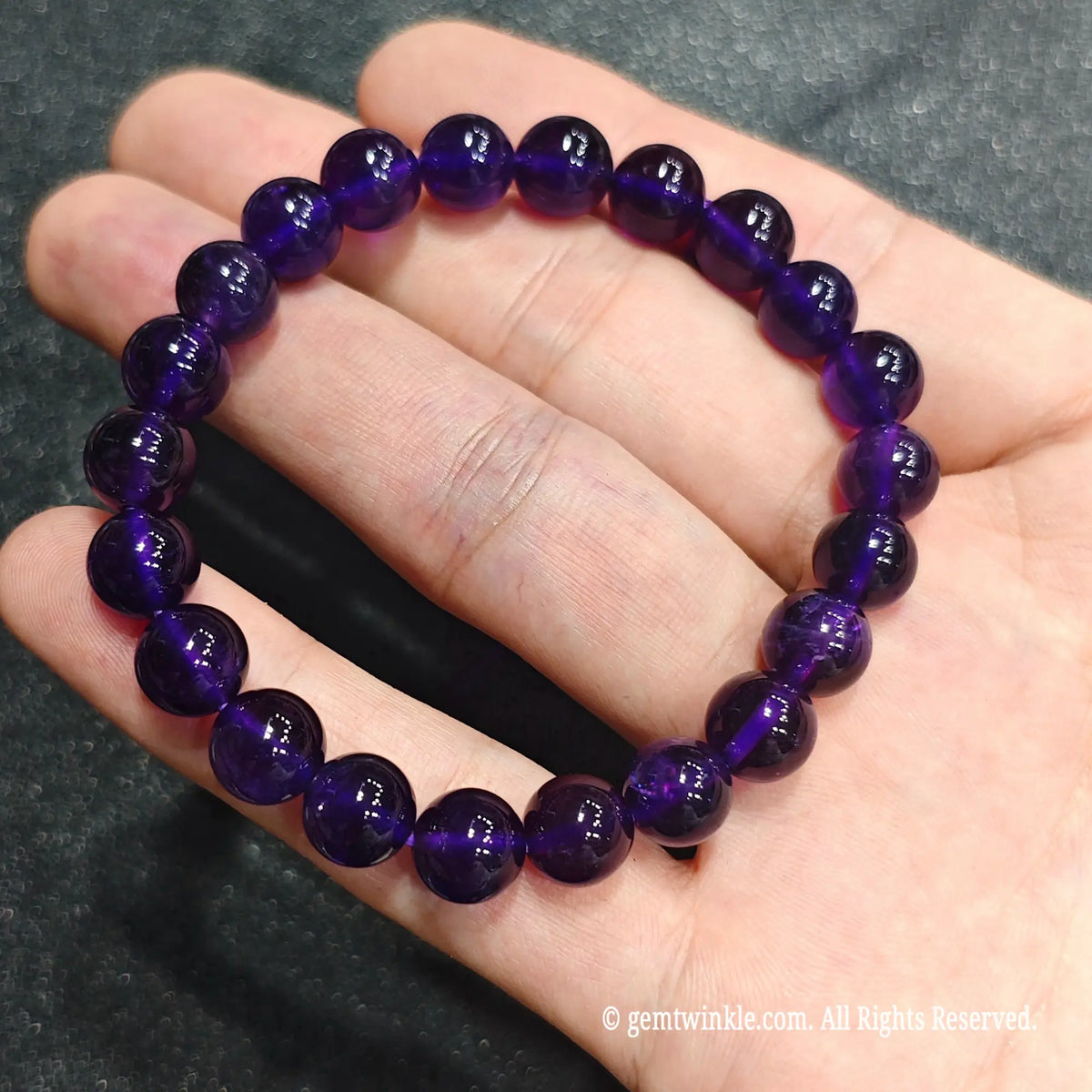 Full circle view of a high clarity royal violet stretch wristlet displayed on hand showing rich purple color depth[cite: 8]