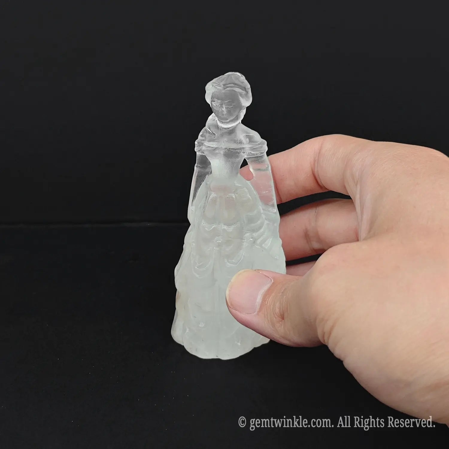 Hand holding an approx 10cm (4 inches) natural milky quartz princess statue to display its dense white color and actual size for wholesale buyers