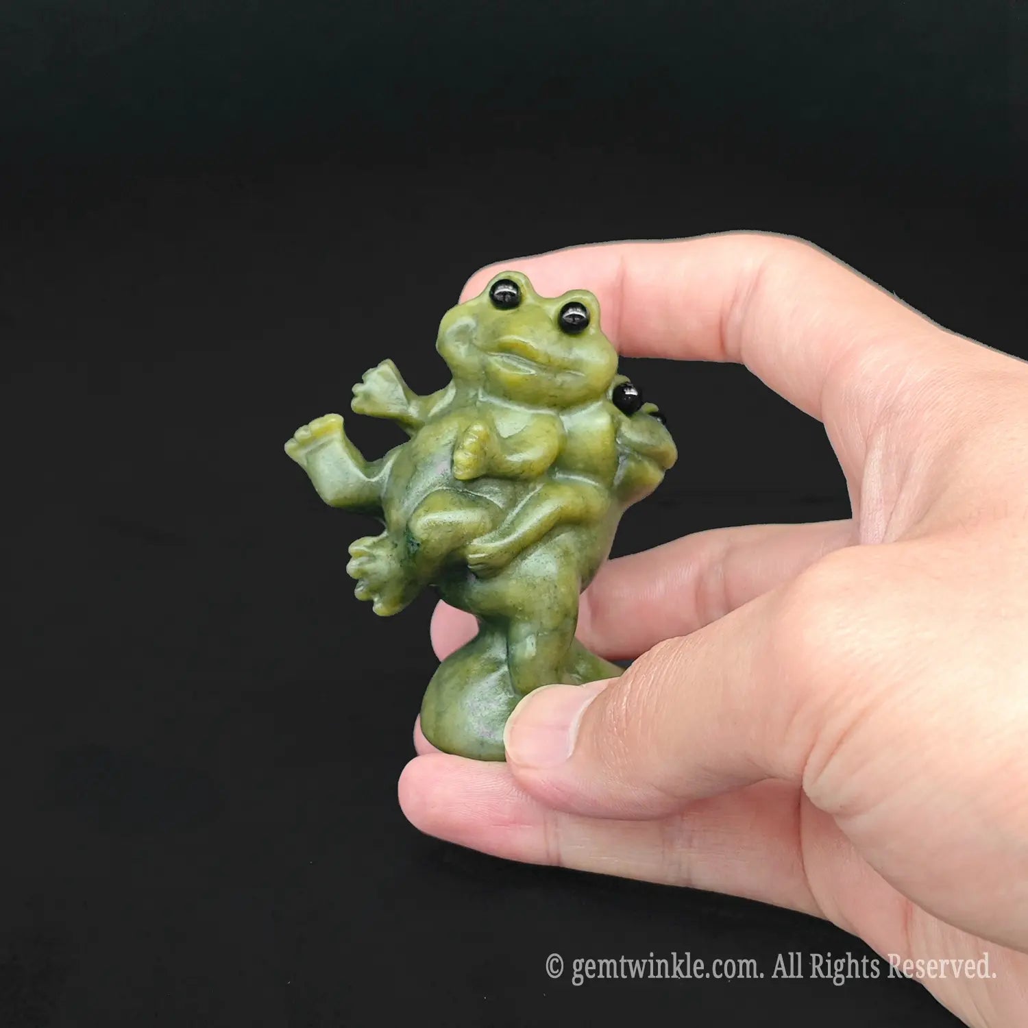 Hand holding a six centimeter funny frog couple figurine to show the physical scale for crystal wholesale buyers