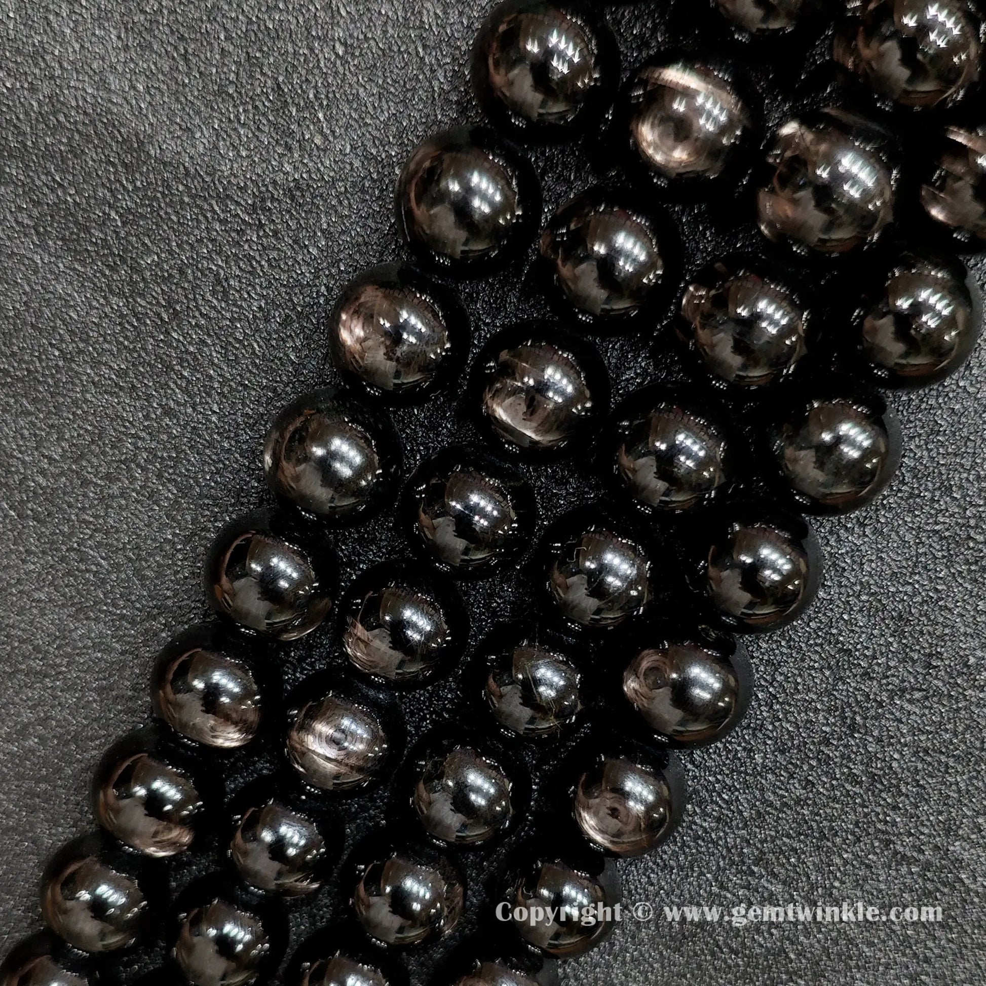 Detailed shot of real B grade golden velvet labradorite crystal beads with natural surface pits and bronze flashes strung on standard jewelry cords