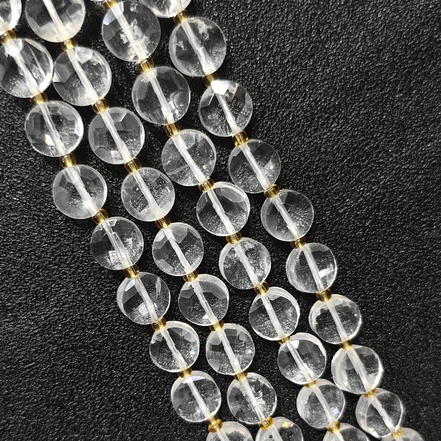 Strands of ice veined clear quartz faceted coin beads in flat disc shape