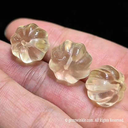 Side angle of 12mm citrine pumpkin loose bead highlighting smooth flute polish and lemon yellow clarity