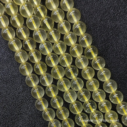 Close up of B plus grade semi translucent jelly like lemon yellow quartz gemstone beads displaying rich oily luster