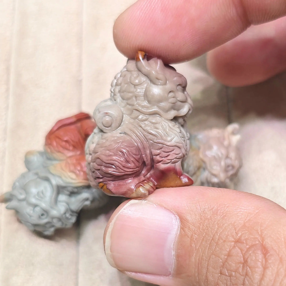 Back perspective of a mini Kirin statue held in hand displaying the scroll resting on its back and carved tail textures