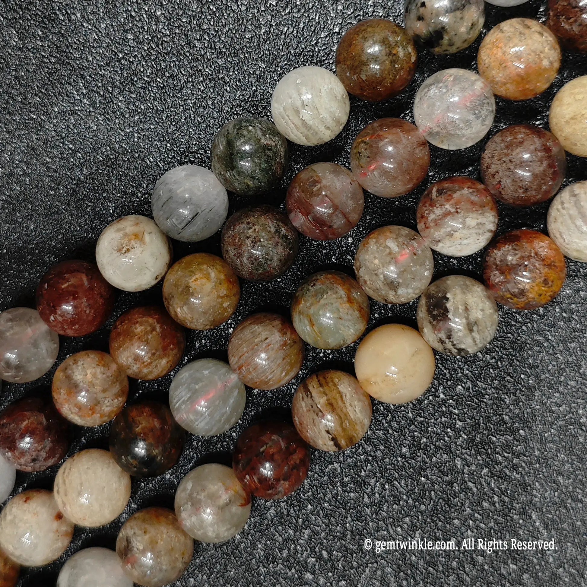 close up of genuine 10mm multi color garden quartz beads displaying unique layered mineral inclusions