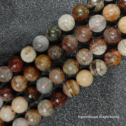 close up of genuine 10mm multi color garden quartz beads displaying unique layered mineral inclusions