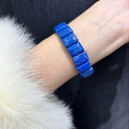 A person wearing a deep blue lapis lazuli bamboo bangle on their wrist, showcasing how the natural stone bracelet fits comfortably for daily wear.