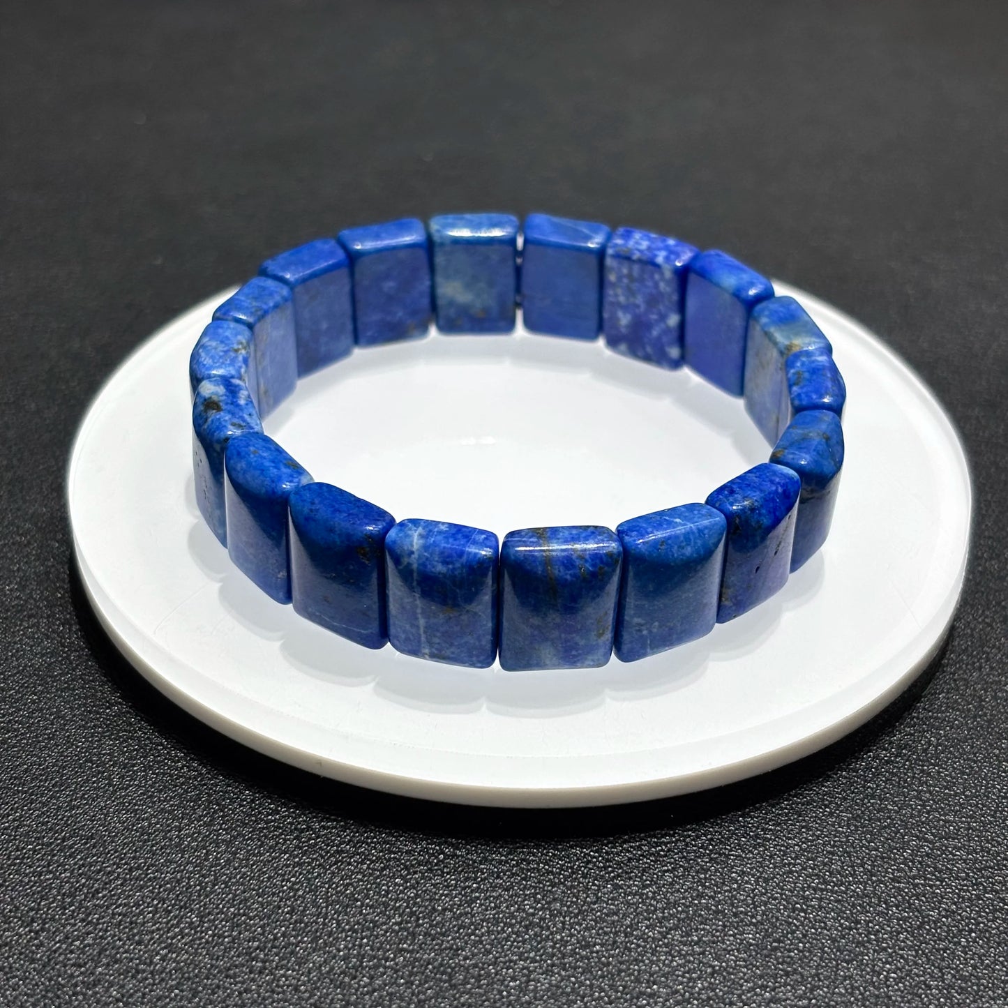 Side view of a natural lapis lazuli rectangular bead bracelet, showing the texture and depth of the blue stones.