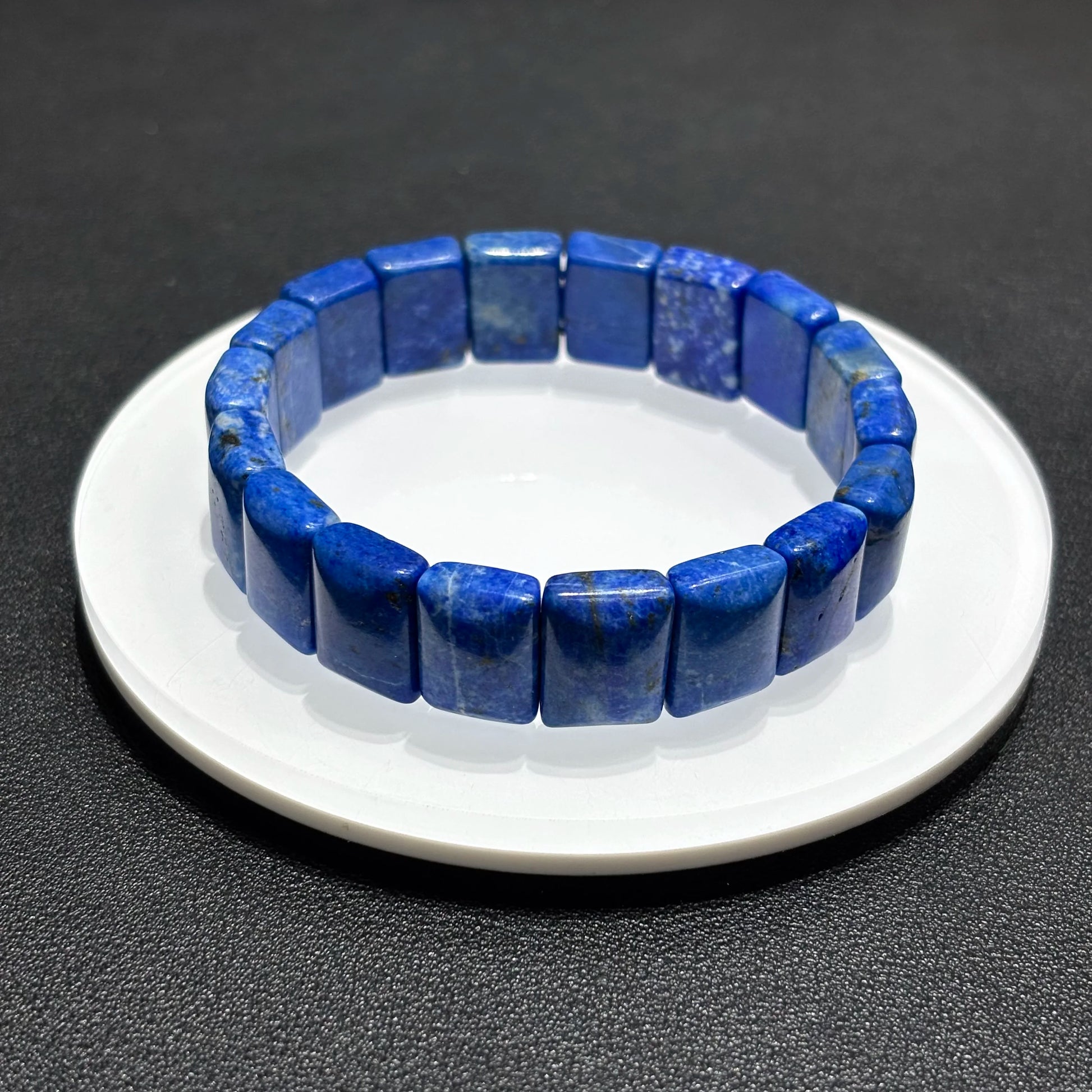 Side view of a natural lapis lazuli rectangular bead bracelet, showing the texture and depth of the blue stones.