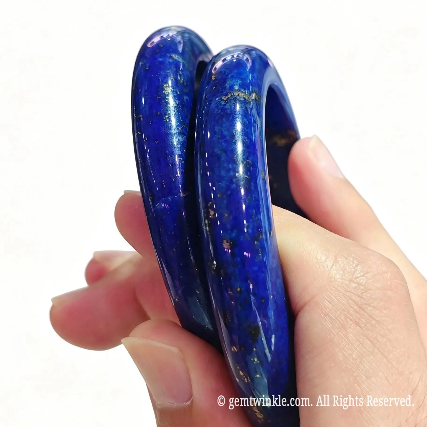 Side angle display of two solid lapis lazuli crystal bangles showcasing rich dark blue hue and solid thickness