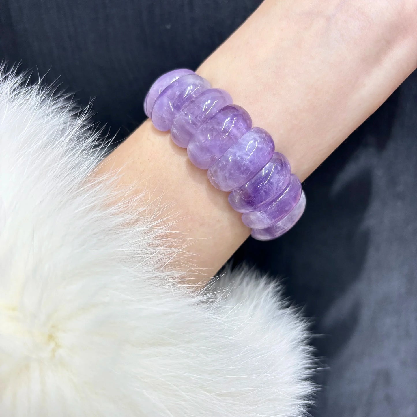Wearing Natural Lavender Amethyst Moon Bead Bracelet on wrist, paired with white fur coat, elegant and calming