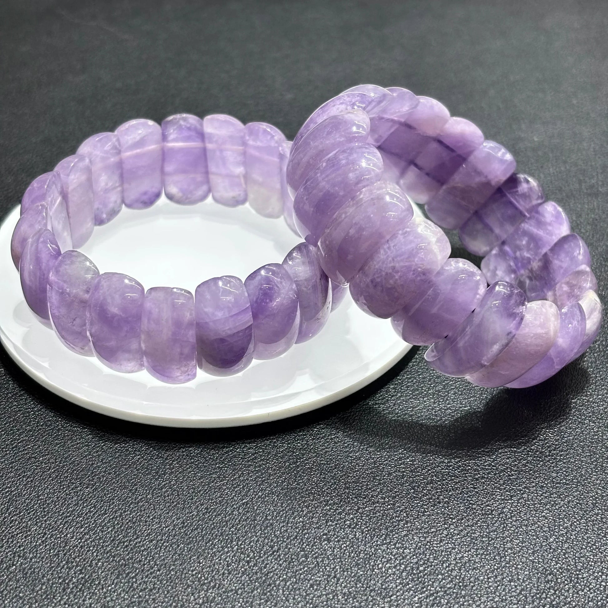  Two Natural Lavender Amethyst Moon Bead Bracelets stacked on white plate, showcasing smooth texture and pastel purple color