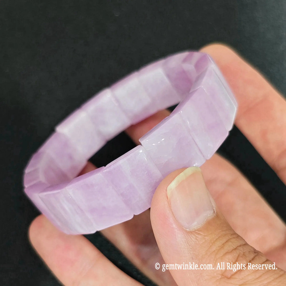 natural lavender pink kunzite bamboo block elastic bangle worn on wrist against dark backdrop
